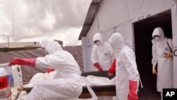 Des travailleurs de la santé évacuant une victime du virus à Ebola au Libéria (AP)