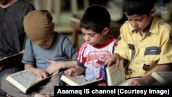 Young boys recite the Quran as part of Islamic State-run school curriculum.