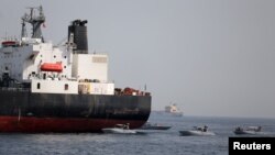 FILE - UAE Navy boats are seen next to Al Marzoqah, Saudi Arabian tanker, off the Port of Fujairah, UAE, May 13, 2019. 