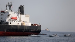 FILE - UAE Navy boats are seen next to Al Marzoqah, Saudi Arabian tanker, off the Port of Fujairah, UAE, May 13, 2019.