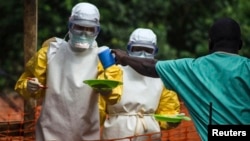 Medecins sans Frontieres (MSF) medical workers deliver food to patients kept in an isolation area at their Ebola treatment center in Kailahun, July 20, 2014.