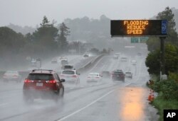 A sign warns motorists of flooding on northbound Highway 101, Feb. 20, 2017, in Corte Madera, Calif.