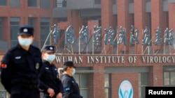 Sejumlah petugas keamanan berjaga di luar Institut Virologi Wuhan saat kunjungan oleh tim Organisasi Kesehatan Dunia untuk meneliti asal muasal COVID-19, di Wuhan, Hubei, China, 3 Februari 2021. (Foto: Thomas Peter/Reuters)