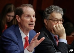 FILE - Sen. Ron Wyden, D-Ore., left, with Sen. Al Franken, D-Minn., join other Democratic senators at a hearing hosted by the Democratic Policy and Communications Committee about how the GOP health care bill could hurt rural Americans, at the Capitol in Washington, June 21, 2017.