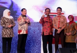 Seorang pelajar SMA bersama Menko Polhukam, Mendagri, Gubernur Jawa Timur, dan Bupati Jombang, usai mencoba mencetak KTP elektronik secara mandiri dengan mesin Anjungan Dikcapil Mandiri. (Foto: VOA/ Petrus Riski).