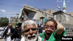An injured girl reacts as she is carried by a man out of a mosque which was attacked by a suicide bomber in Sanaa, Yemen, March 20, 2015. 