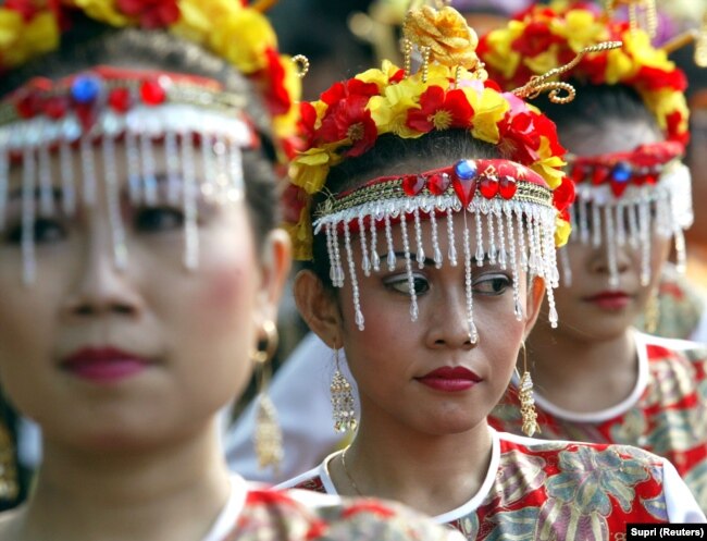 Perempuan berbusana adat mengikuti karnaval jalanan di Jakarta Pusat, 25 Juli 2004. (Foto: REUTERS/Supri)