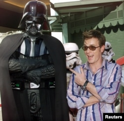 Scottish actor Ewan McGregor, who portrayed Obi-Wan Kenobi in "Star Wars Episode II Attack of the Clones," poses with Star Wars character Darth Vader and Storm Troopers in background at the Los Angeles charity premiere of the film, May 12, 2002, in Hollywood.