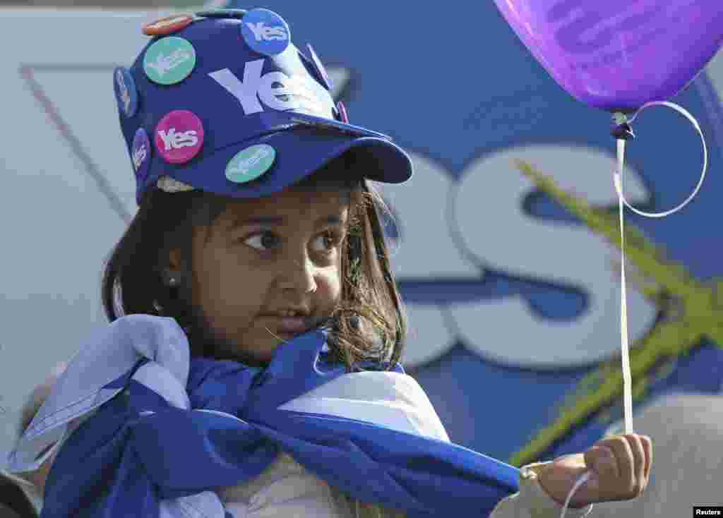 A young girl wears a 'Yes' hat, covered in 'Yes' badges, as Scotland's First Minister Alex Salmond campaigns in Edinburgh, Scotland.