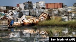 In this photo taken Monday, Oct. 1, 2018, containers used for hazardous chemicals lie exposed and piled up at a junkyard run by the Chinese-led Dar Petroleum Operating Company in Gumry, near Paloch, in South Sudan.