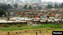 Children play on the way home after school in Pumwani slums near Kenya's capital Nairobi, seen in the background, September 14, 2006.