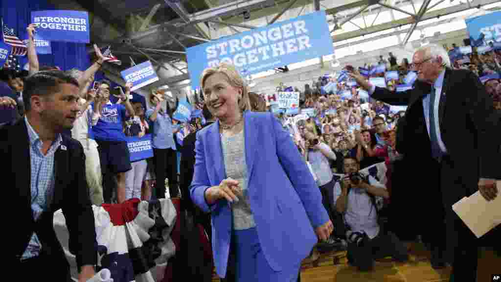 Mgopmbea kiti cha rais wa chama cha Demokratic Hillary Clinton, akifuatanma na Seneta Bernie Sanders, fwakiingia kwenye mkutano wa Portsmouth, 12 Juillet, 2016.