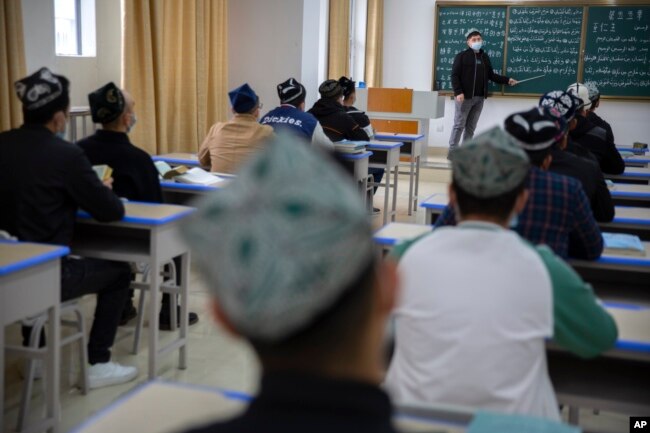 FILE - Students training to become imams recite verses from the Quran at the Xinjiang Islamic Institute in Urumqi, the capital of China's far west Xinjiang region, during a government organized visit for foreign journalists, April 21, 2021.