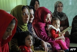 Women and young girls listen to Kurdistan Rasul (not pictured), an Iraqi Kurdish activist with the nonprofit organization WADI, as she speaks about the harms of genital mutilation in Sharboty Saghira, Iraq, Dec. 3, 2018.