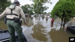 Personil Patroli Perbatasan A.S, memeriksa untuk melihat apakah orang-orang yang mengarungi air membutuhkan bantuan saat operasi pencarian dan penyelamatan di sebuah wilayah yang banjir akibat Badai Tropis Harvey di Houston, Texas, 30 Agustus 2017.