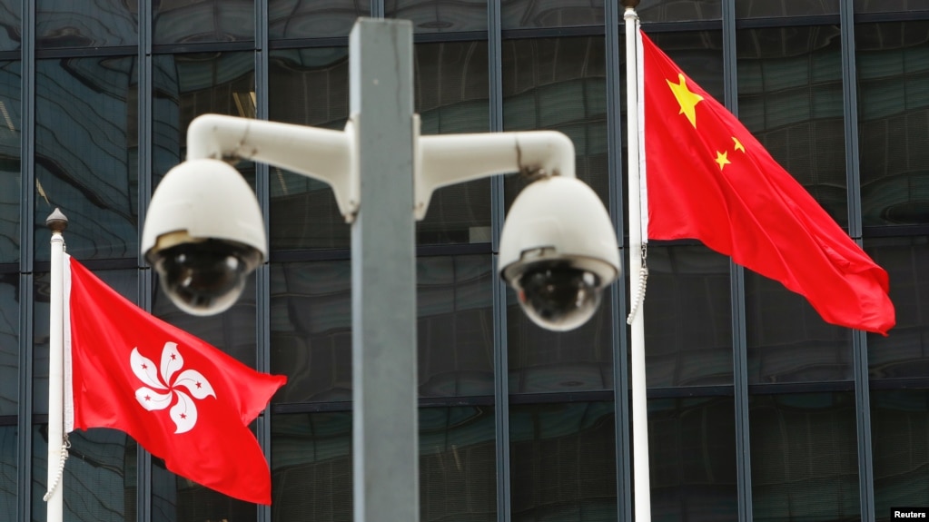 Hong Kong and Chinese national flags are flown behind a pair of surveillance cameras (photo:VOA)