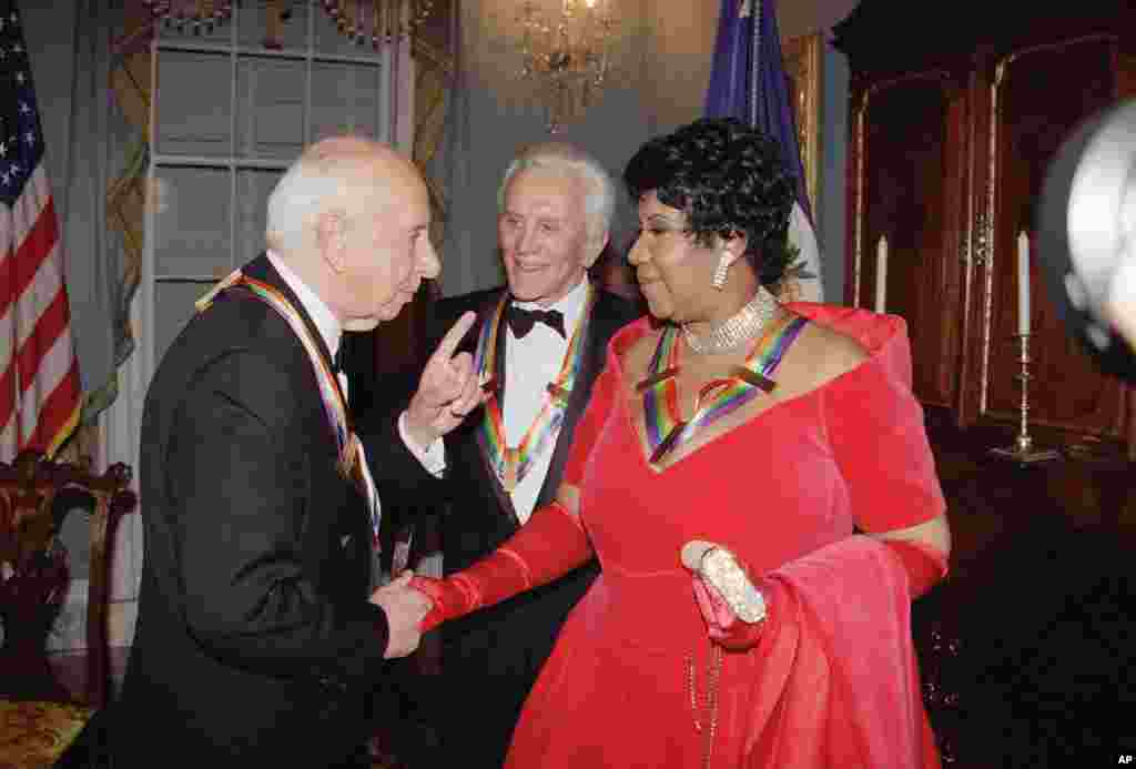 Singer Aretha Franklin listens to composer Morton Gould, as actor Kirk Douglas looks on following a dinner at the State Department in Washington, Dec. 3, 1994.