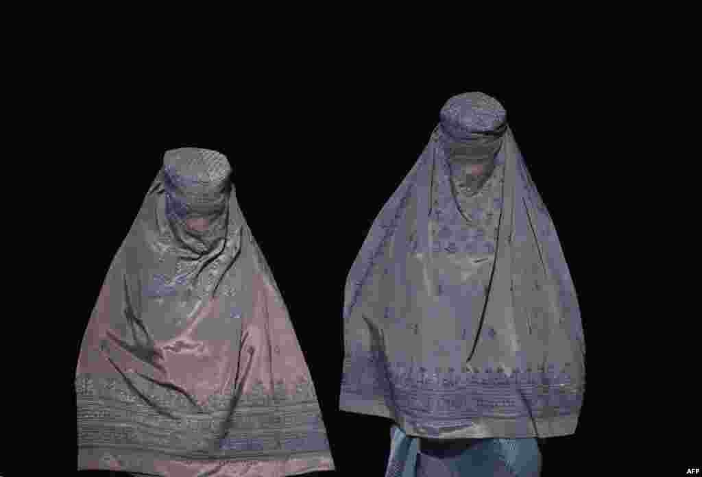 Afghan burqa-clad women leave a shop at a market in Mazar-i-Sharif.