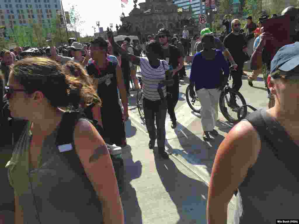 Black Lives Matter activists chanted as they walked away from Public Square, while police officers on bicycles rode in a line next to them, trying to keep them on the sidewalk and in one lane of traffic, in Cleveland, July 19, 2016.