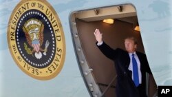 도널드 트럼프 미국 대통령이 25일 앤드류스 공군기지에서 베트남으로 향하는 에어포스 원 비행기에 탑승한 후 손을 들어 인사하고 있다.