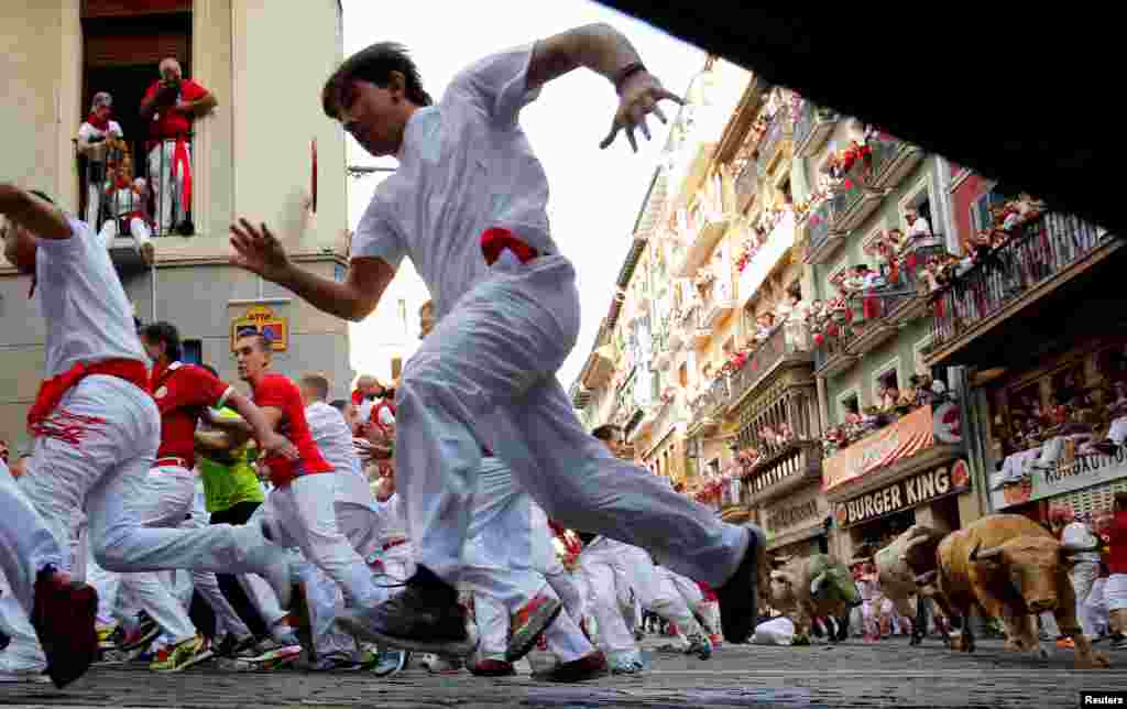 Runners sprint ahead of bulls during the first running of the bulls at the San Fermin festival in Pamplona, northern Spain.