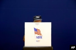 A voter fills out a ballot at a polling place at Lake Shore Elementary School, Nov. 6, 2018, in Pasadena, Md.