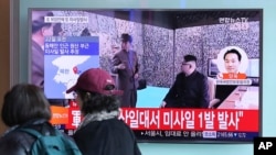 Visitors walk by a TV screen showing a news program with a file footage of North Korean leader Kim Jong Un at the Seoul Train Station in Seoul, South Korea, March 22, 2017. North Korea's latest missile launch ended in failure Wednesday. The Korean letters read: "Launch a missile." 