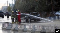 Afghan firefighters clean up the site of a deadly suicide bombing, in Kabul, Afghanistan, Nov. 16, 2017. 