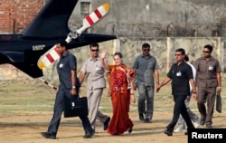 Chief of India's ruling Congress party Sonia Gandhi (C), surrounded by her security personnel, waves to her supporters after addressing an election campaign rally at Rae Bareli in Uttar Pradesh, Apr. 26, 2014.