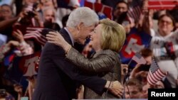 Hillary Clinton ki tap anbrase mari li, Bill Clinton, apre diskou li fè pou l rekonèt viktwa li nan 4 eta sou 5 madi 26 avril 2016 la.