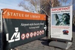 FILE - A sign announcing the closure of the Statue of Liberty, due to the U.S. government shutdown, sits near the ferry dock to the Statue of Liberty at Battery Park in Manhattan, New York, Jan. 20, 2018.