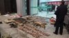 In this Jan. 9, 2020, photo provided by the Anti-Poaching Special Squad, police look at items seized from store suspected of trafficking wildlife in Guangde city in central China's Anhui Province.