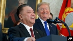 President Donald Trump smiles at Broadcom CEO Hock Tan during an event to announce that the company is moving its global headquarters to the United States, in the Oval Office of the White House, Nov. 2, 2017.