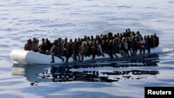 FILE - Migrants are seen in a rubber dinghy as they are rescued by the Libyan coast guard in the Mediterranean Sea off the coast of Libya, Jan. 15, 2018. 