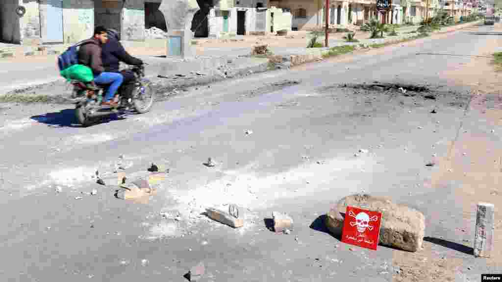 Deux hommes roulent une moto sur le lieu de l&#39;attaque présumée chimique dans la ville de Khan Sheikhoun, le 5 avril 2017.