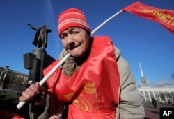 Communist Valentina, 73, attends celebration of the 100th anniversary of the 1917 Bolshevik Revolution near a statue of Soviet Union founder Vladimir Lenin in St. Petersburg, Russia, Nov. 7, 2017.