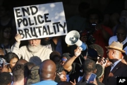 Demonstrators gather near a community pool during a protest Monday, June 8, 2015, in response to an incident at the pool involving McKinney police officers in McKinney, Texas.