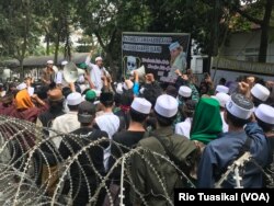 Puluhan hingga ratusan pendukung Bahar Smith berorasi di depan Gedung Perpustakaan dan Kearsipan tempat sidang berlangsung. (Foto: VOA/Rio Tuasikal)