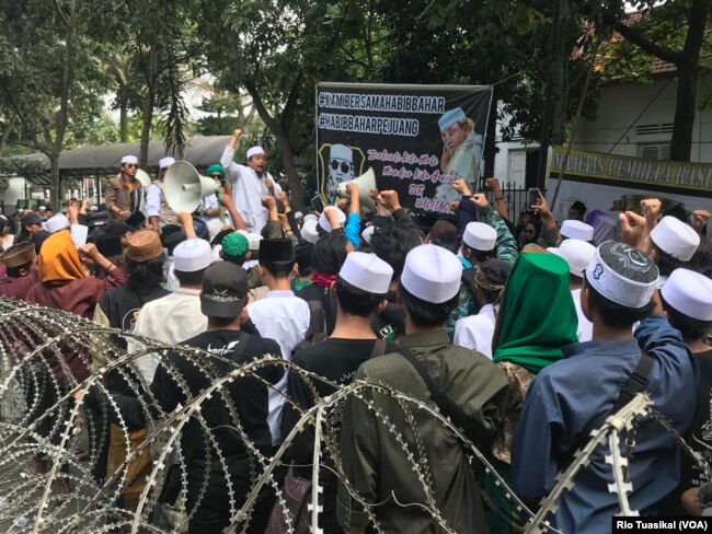 Puluhan hingga ratusan pendukung Bahar Smith berorasi di depan Gedung Perpustakaan dan Kearsipan tempat sidang berlangsung. (Foto: VOA/Rio Tuasikal)