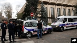 Police officers and riot police officer stand outside the Russian embassy in Paris, Monday, March 26, 2018. (AP Photo/Christophe Ena)