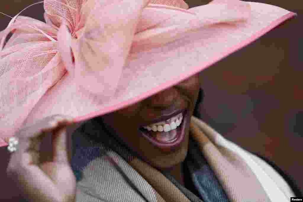 A racegoer smiles during Ladies Day, the second day of racing at the Cheltenham Festival horse racing meet in Gloucestershire, western England.