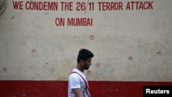 A man walks past a wall riddled with bullet holes opposite to the Nariman House, one of the targets of the November 26, 2008 attacks, after the renaming ceremony of Nariman House as Nariman Light House in Mumbai, India, November 25, 2018.