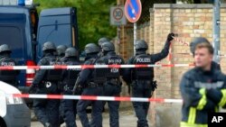 La policía camina frente a un cementerio judío en Halle, Alemania, el miércoles. La policía dice que una persona fue arrestada después del tiroteo. Oct, 9 de 2019. AP/Jens Meyer.