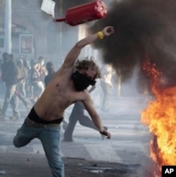 A protester hurls a canister during demonstration in Rome, Saturday, October 15, 2011.