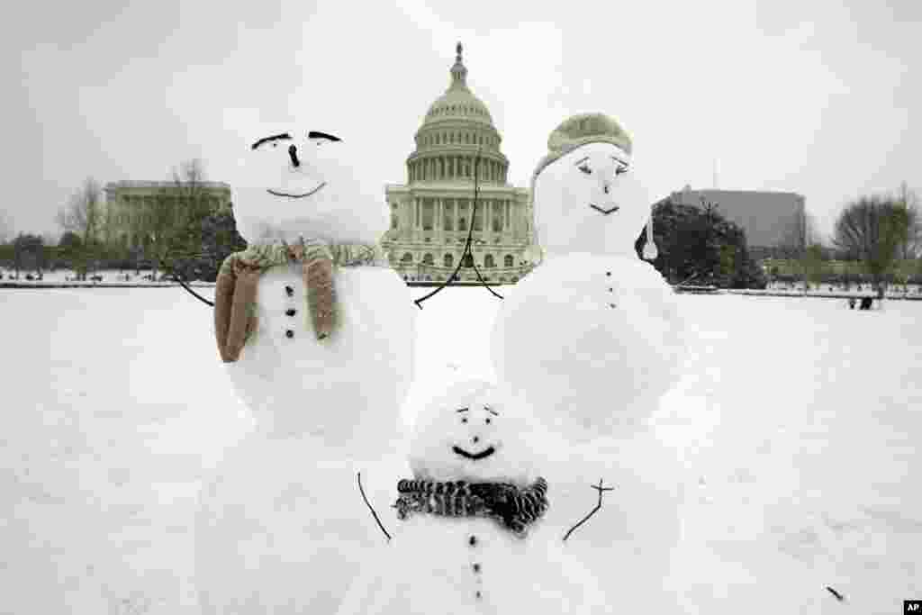 눈이 내린 미국 워싱턴 D.C. 의 연방의사당 앞에 눈사람 가족이 놓여 있다.&nbsp;