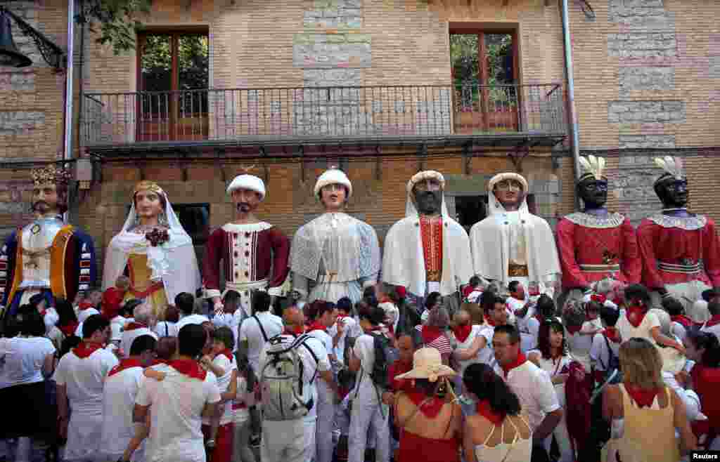 Revelers take part in the &quot;Comparsa de gigantes y cabezudos&quot; (Giants and Big Heads Parade) during the San Fermin festival in Pamplona, Spain.