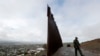 Border Patrol agent Vincent Pirro walks near where the border wall ends that separates Tijuana, Mexico, left, from San Diego, right, Feb. 5, 2019, in San Diego. 