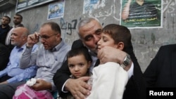 哈马斯领导人哈尼耶亲吻被以色列空袭打死的哈马斯军事指挥官贾巴里的儿子(2012年11月22日)