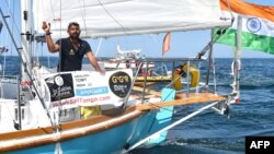 FILE - India's Abhilash Tomy gestures on his boat Thuriya as he sets off from Les Sables d'Olonne Harbor at the start of the solo around-the-world Golden Globe Race in which sailors compete without high-tech aides such as GPS or computers, July 1, 2018.