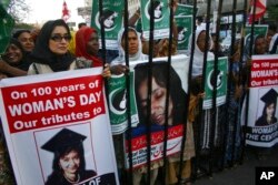 FILE - People rally demanding the release of Aafia Siddiqui, who was convicted in Feb. 2010 of two counts of attempted murder, and who is currently being detained in the U.S., during International Women's Day in Karachi, Pakistan, March 8, 2011.